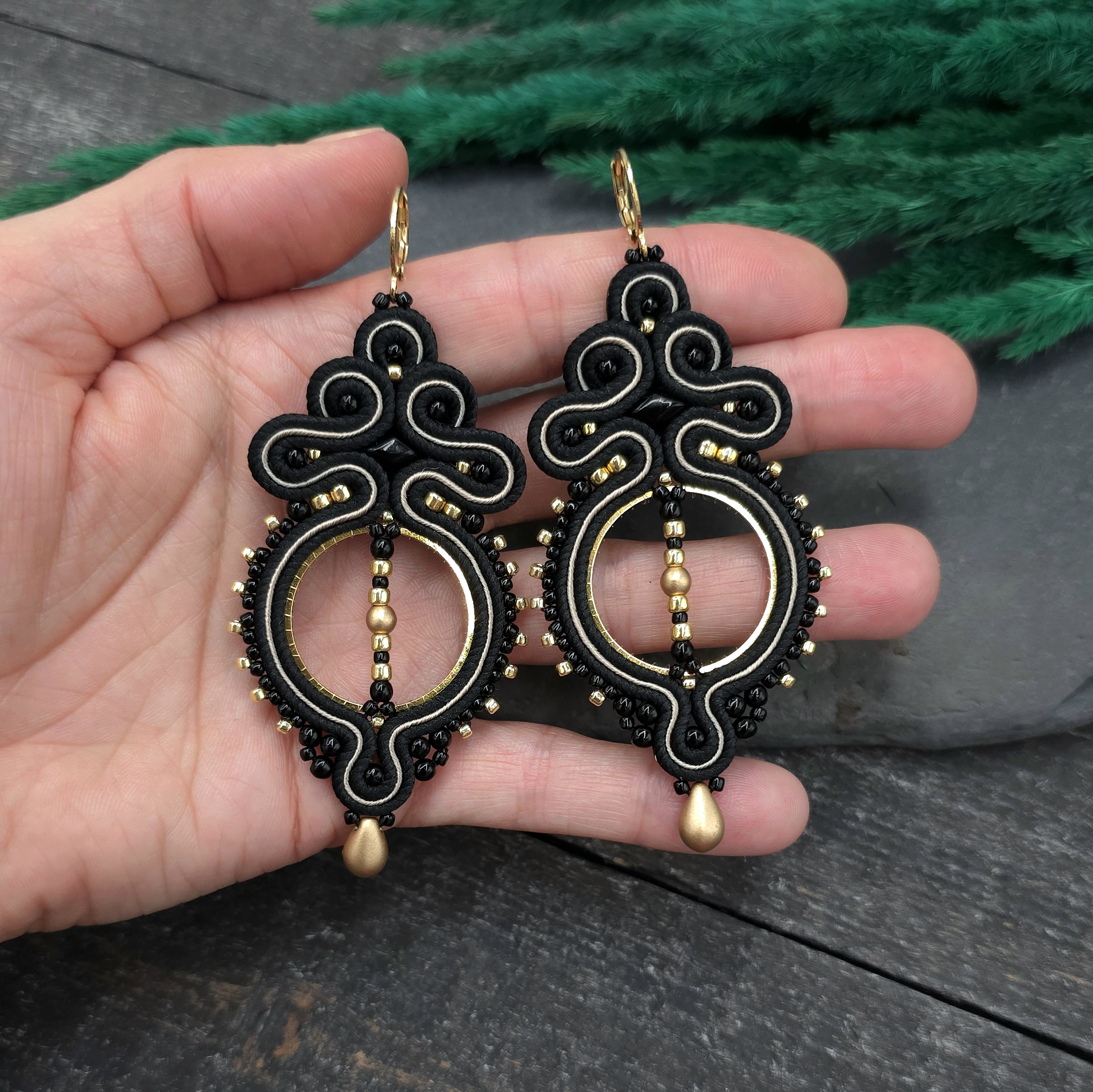 Kolczyki sutasz czarne lekkie wiszące eleganckie koła handmade wieczorowe biżuteria artystyczna marki Katrina Rossa na dłoni